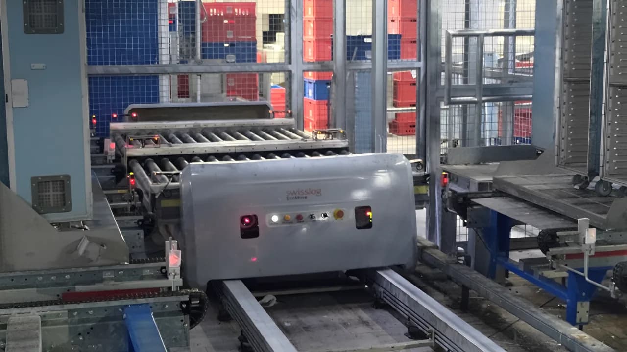 Automated guided vehicle carrying containers on a catering production line