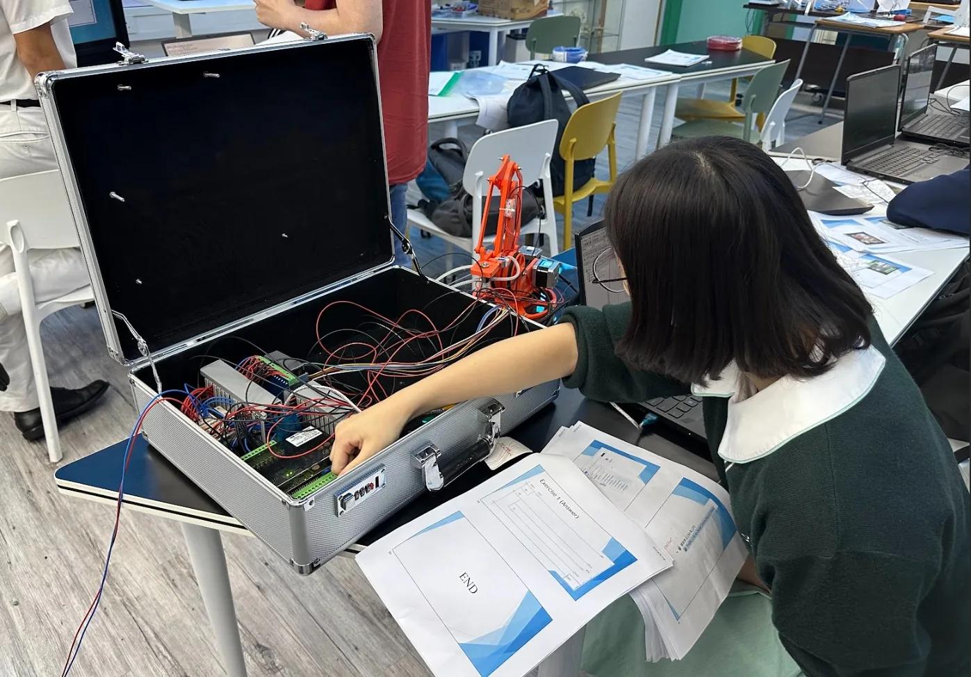 學生為便攜式 PLC 及機械人培訓箱接線