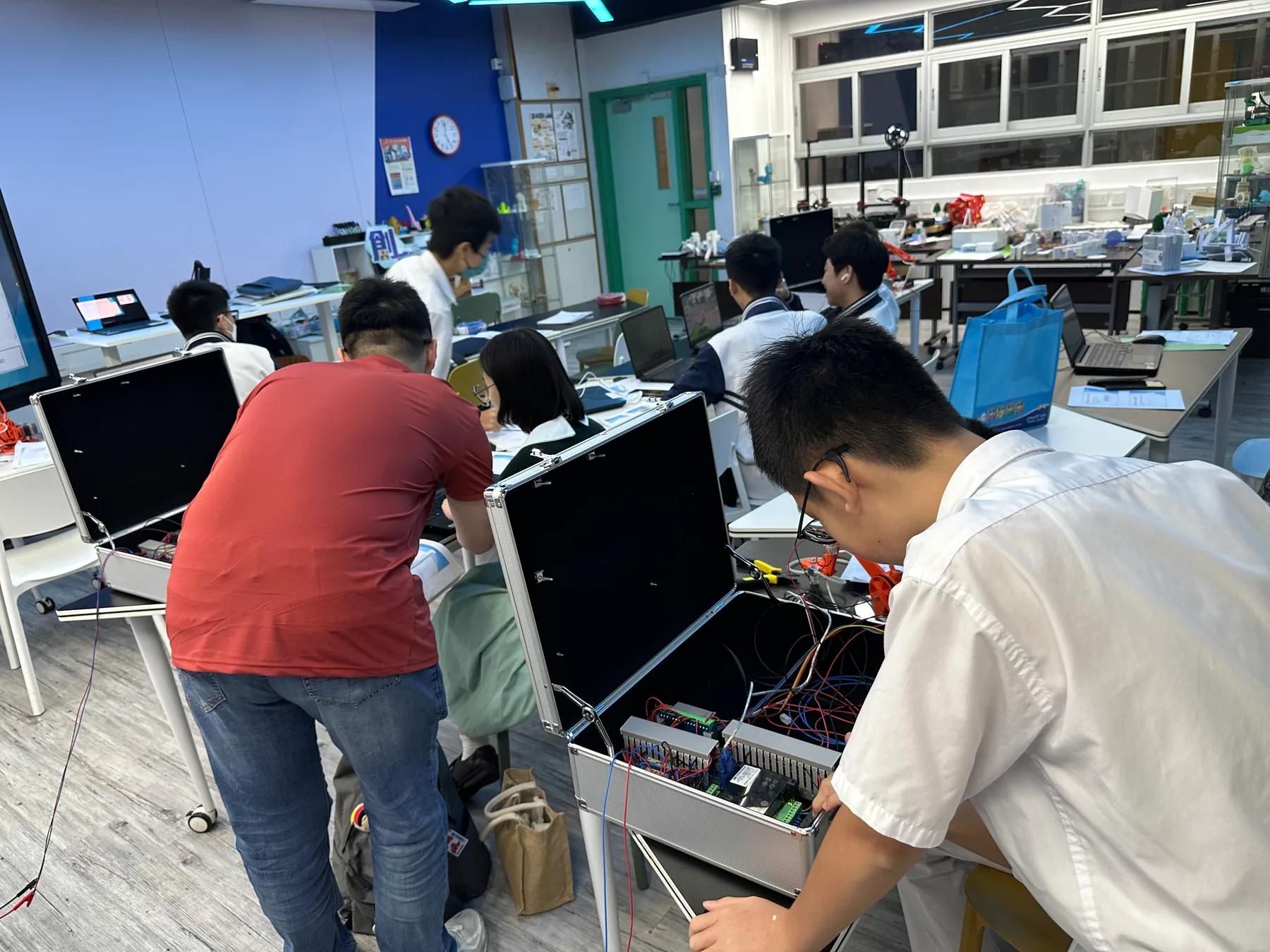 導師協助學生使用 PLC 及機械人培訓設備